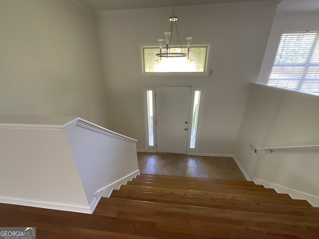 foyer entrance with stairs, baseboards, and wood finished floors