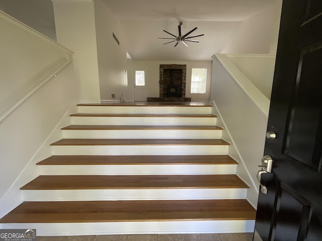 staircase featuring ceiling fan, visible vents, and lofted ceiling