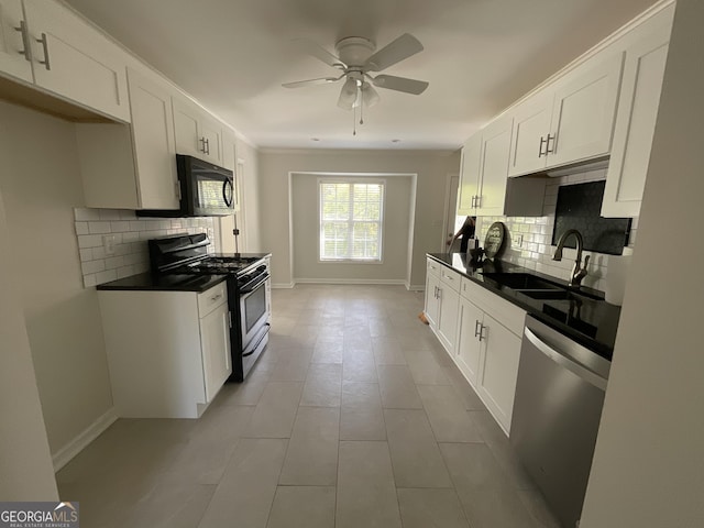 kitchen with black microwave, a sink, dishwasher, backsplash, and gas range oven