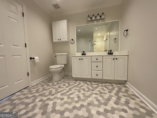 bathroom with a sink, toilet, double vanity, baseboards, and a shower with door