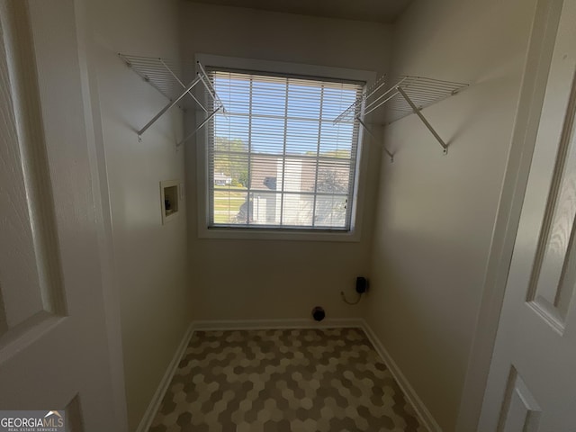clothes washing area featuring baseboards, laundry area, and hookup for a washing machine