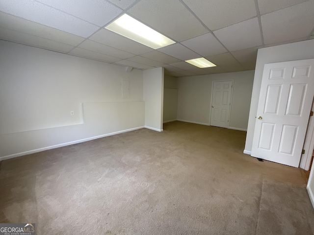 below grade area featuring carpet floors, baseboards, and a paneled ceiling