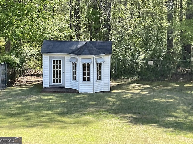 view of outdoor structure featuring fence and an outdoor structure