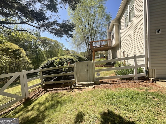 view of gate with fence and a yard