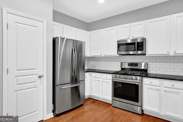 6330 Elmshorn Way, Alpharetta, GA 30004 - kitchen with tasteful backsplash, light wood finished floors, white cabinetry, and stainless steel appliances