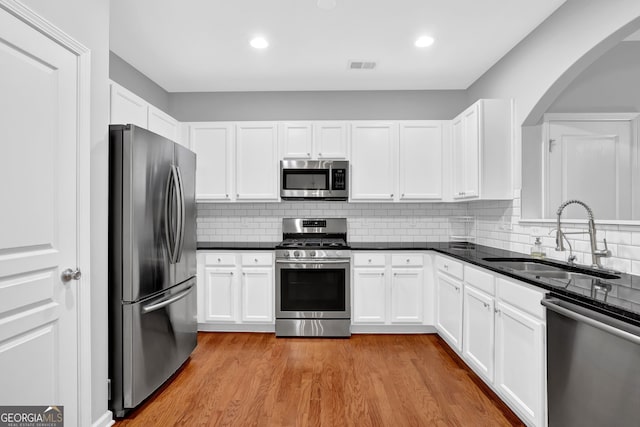 6330 Elmshorn Way, Alpharetta, GA 30004 - kitchen with white cabinetry, visible vents, appliances with stainless steel finishes, arched walkways, and a sink