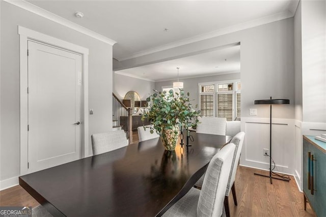 111 Brighton Blvd, Woodstock, GA 30188 - dining space with wood finished floors, ornamental molding, a wainscoted wall, and stairs
