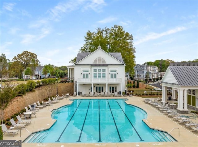111 Brighton Blvd, Woodstock, GA 30188 - rear view of house with a community pool, a patio area, metal roof, fence, and a balcony