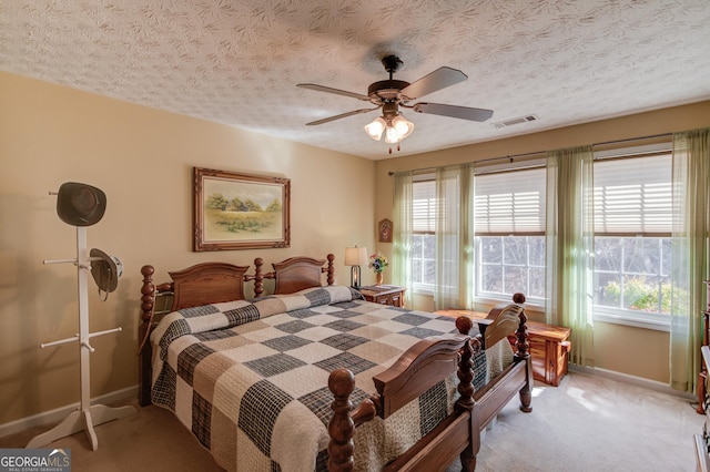 bedroom with baseboards, visible vents, multiple windows, and light colored carpet