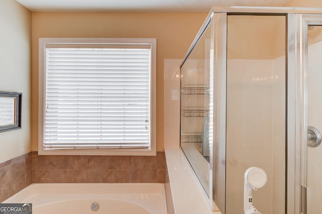 bathroom with a shower stall and a garden tub