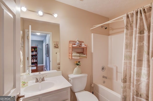 bathroom featuring toilet, shower / bath combo, vanity, and a textured ceiling