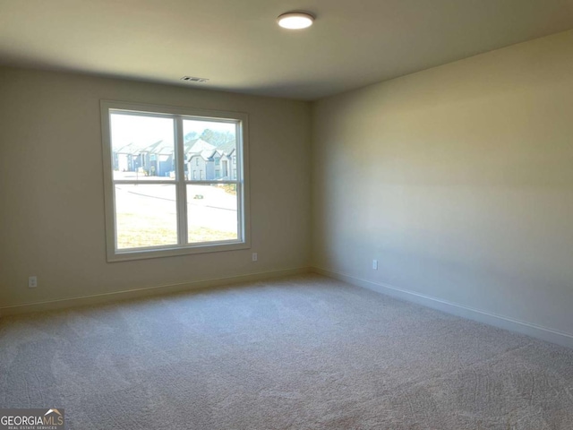 carpeted empty room featuring baseboards