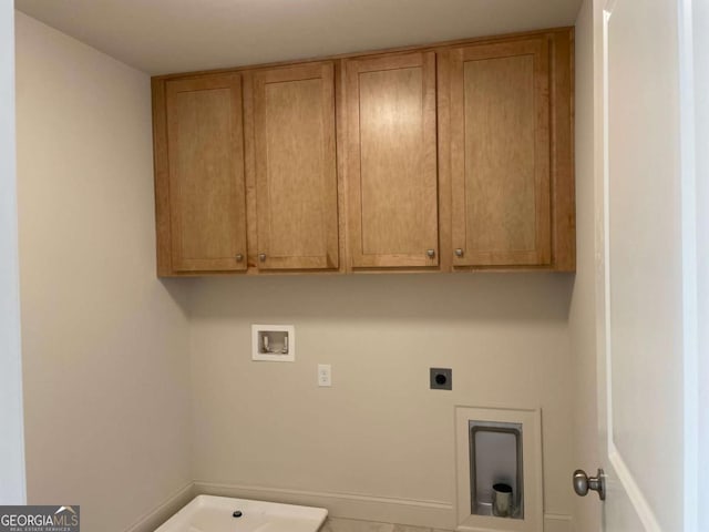 washroom with hookup for an electric dryer, hookup for a washing machine, and cabinet space