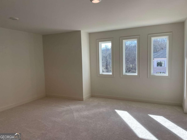 empty room with light carpet and baseboards