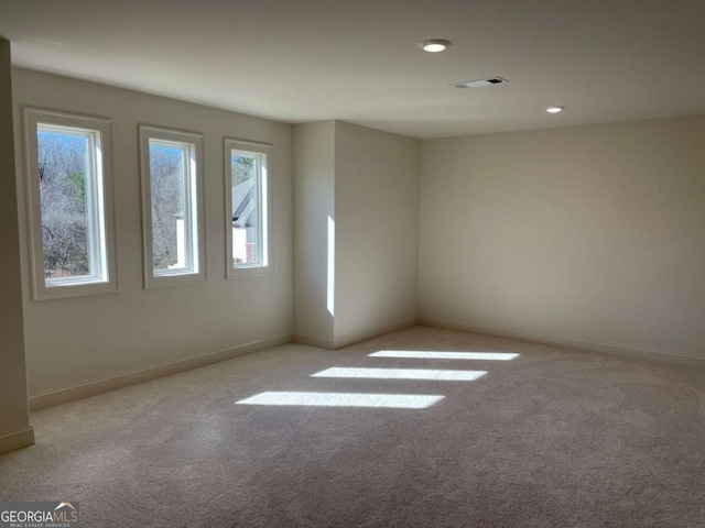 unfurnished room with a wealth of natural light, baseboards, and carpet floors