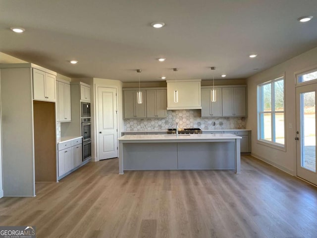 kitchen with a sink, light countertops, tasteful backsplash, and appliances with stainless steel finishes