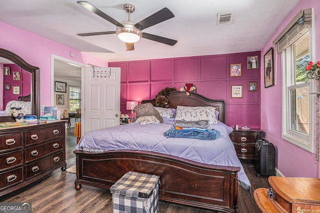 bedroom featuring wood finished floors, multiple windows, and ceiling fan