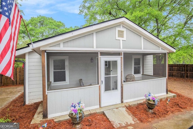 view of front facade with a sunroom and fence