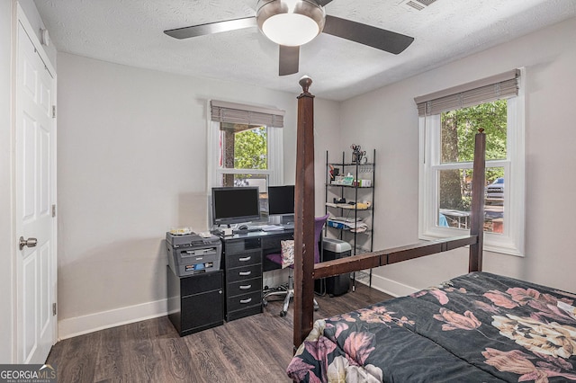 bedroom featuring dark wood-style flooring, a desk, baseboards, a textured ceiling, and ceiling fan