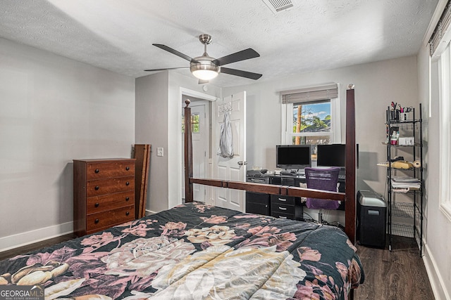 bedroom with wood finished floors, baseboards, a textured ceiling, a ceiling fan, and a desk