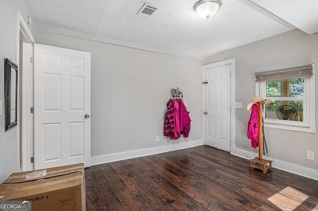 unfurnished bedroom featuring dark wood finished floors, baseboards, and a textured ceiling