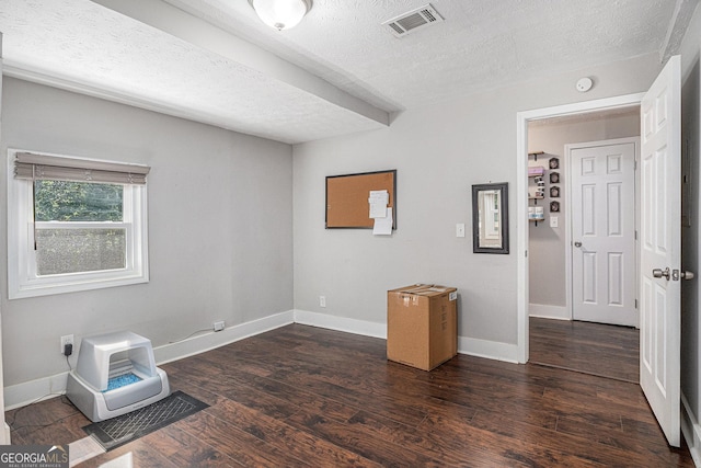 spare room featuring a textured ceiling, dark wood finished floors, baseboards, and a smoke detector