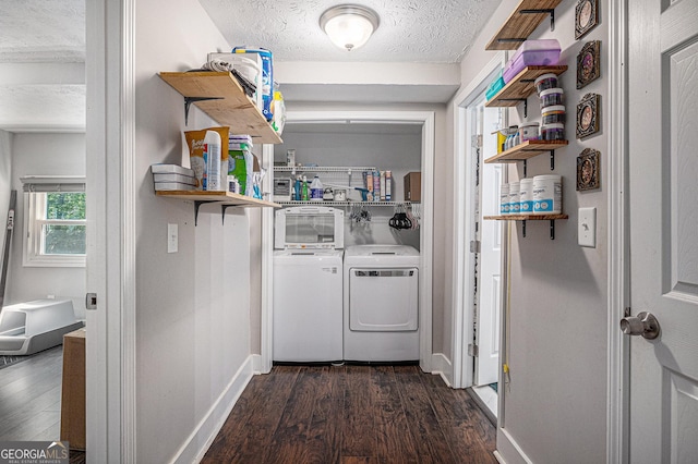 clothes washing area featuring washer and clothes dryer, a textured ceiling, dark wood-type flooring, and baseboards