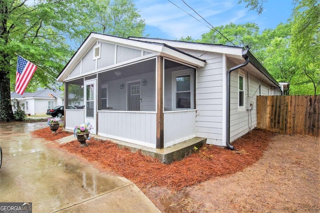 view of front facade featuring fence and a sunroom