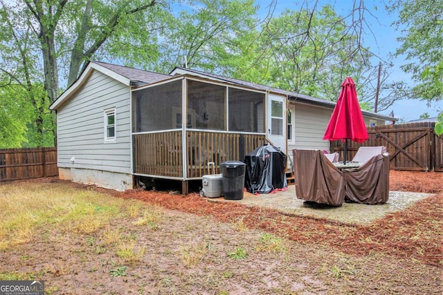 back of house featuring a sunroom and a fenced backyard