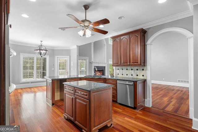 kitchen with crown molding, stainless steel dishwasher, wood finished floors, and ceiling fan with notable chandelier