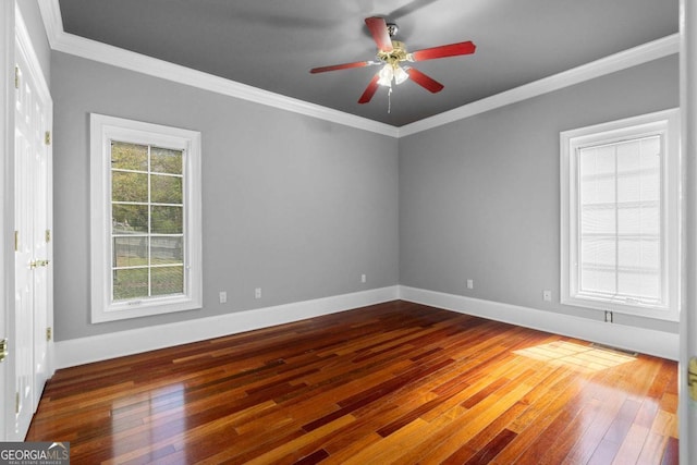 unfurnished room featuring crown molding, wood-type flooring, ceiling fan, and baseboards