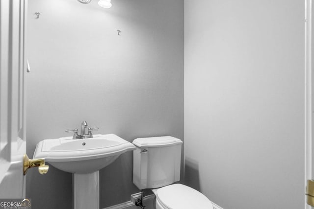 bathroom with toilet and baseboards