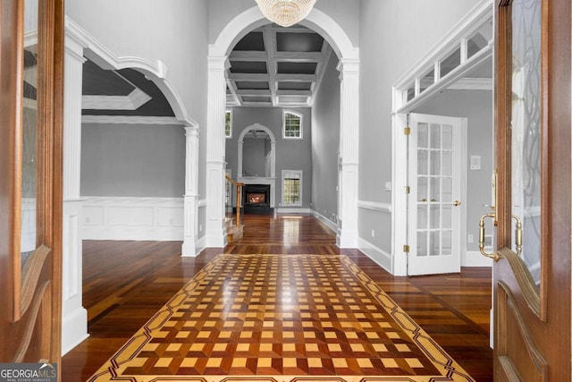 entrance foyer featuring dark wood-type flooring, french doors, a fireplace, and coffered ceiling