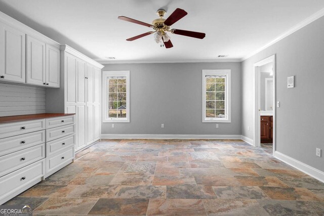 unfurnished bedroom featuring stone finish flooring, visible vents, baseboards, and ornamental molding