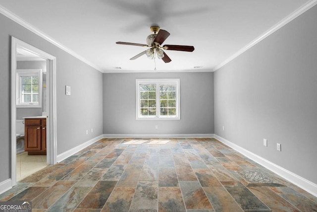 unfurnished room featuring stone finish floor, baseboards, crown molding, and ceiling fan