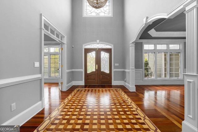 entrance foyer featuring french doors, wood finished floors, a high ceiling, and baseboards