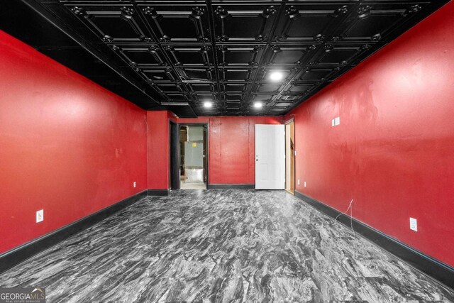 spare room featuring baseboards and an ornate ceiling