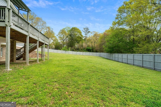 view of yard with a fenced backyard, stairway, and a wooden deck