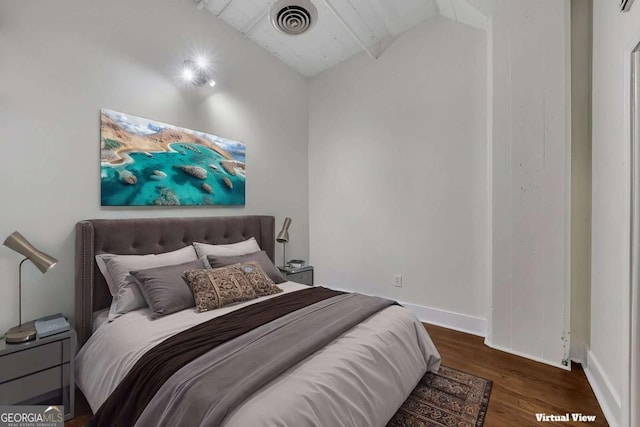 bedroom featuring visible vents, baseboards, vaulted ceiling, and wood finished floors