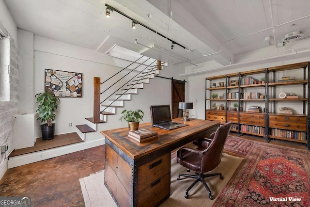 home office featuring concrete flooring, baseboards, and a barn door