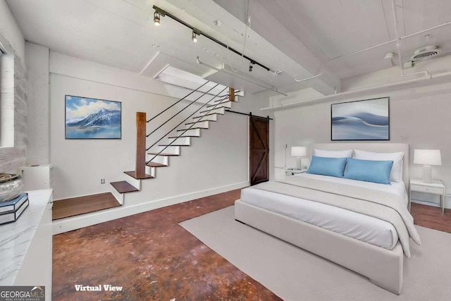 bedroom featuring concrete flooring, baseboards, and a barn door