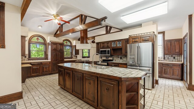 316 E 3rd Ave, Rome, GA 30161 - kitchen with appliances with stainless steel finishes, a sink, decorative backsplash, brick patterned flooring, and lofted ceiling