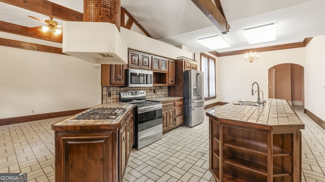 316 E 3rd Ave, Rome, GA 30161 - kitchen with appliances with stainless steel finishes, a sink, brick patterned floors, arched walkways, and beamed ceiling