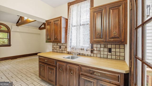316 E 3rd Ave, Rome, GA 30161 - kitchen with backsplash, a sink, wood counters, baseboards, and brick patterned floors