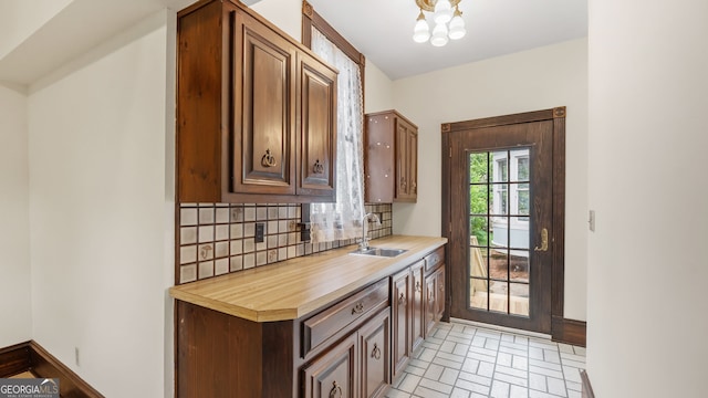 316 E 3rd Ave, Rome, GA 30161 - kitchen featuring a sink, backsplash, light countertops, a chandelier, and baseboards