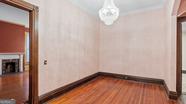 316 E 3rd Ave, Rome, GA 30161 - unfurnished dining area featuring hardwood / wood-style floors, a chandelier, baseboards, a stone fireplace, and ornamental molding