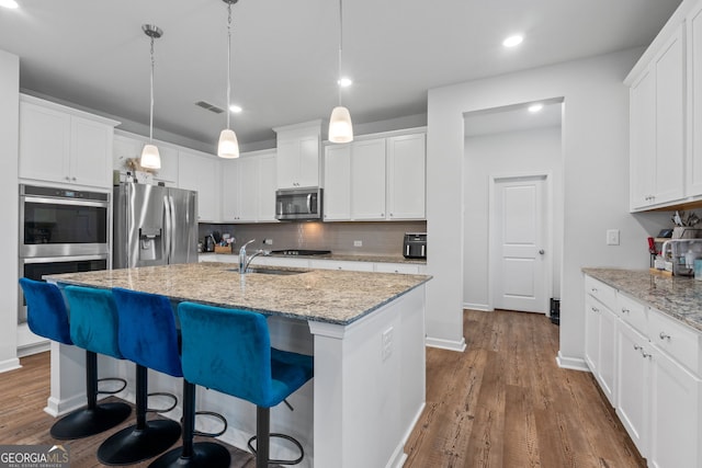 kitchen featuring tasteful backsplash, visible vents, dark wood-style flooring, a sink, and stainless steel appliances