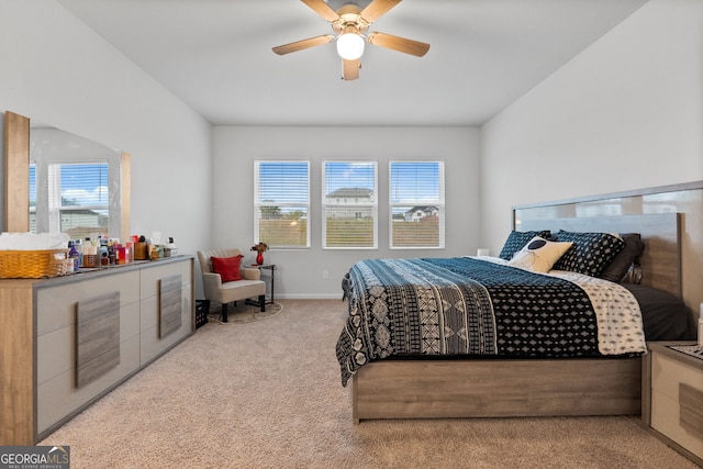 bedroom with light carpet, baseboards, and a ceiling fan