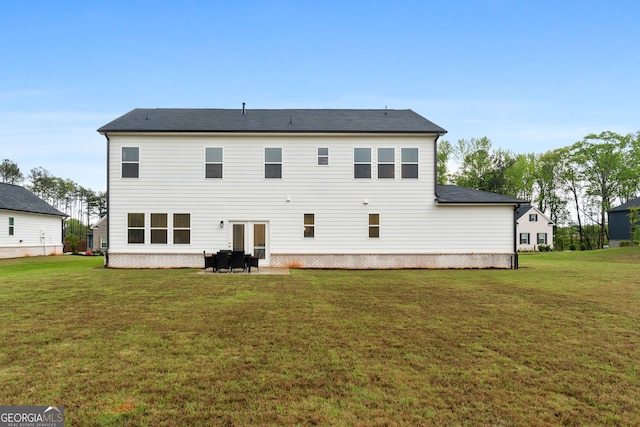 back of property with a yard and a patio