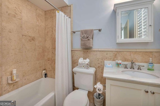 17 Sea Oats Ln, Saint Simons, GA 31522 - bathroom with shower / tub combo, tile walls, toilet, vanity, and wainscoting